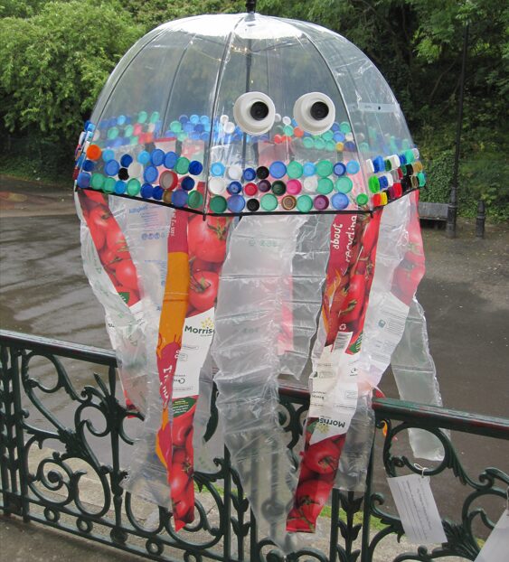 A photograph of an old umbrella, decorated with single use plastic to look like a Jellyfish