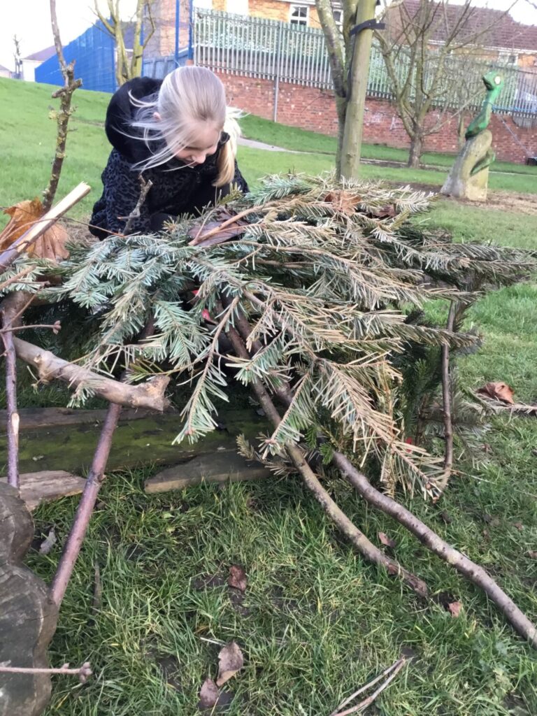Child building a den at Thornhill Primary School