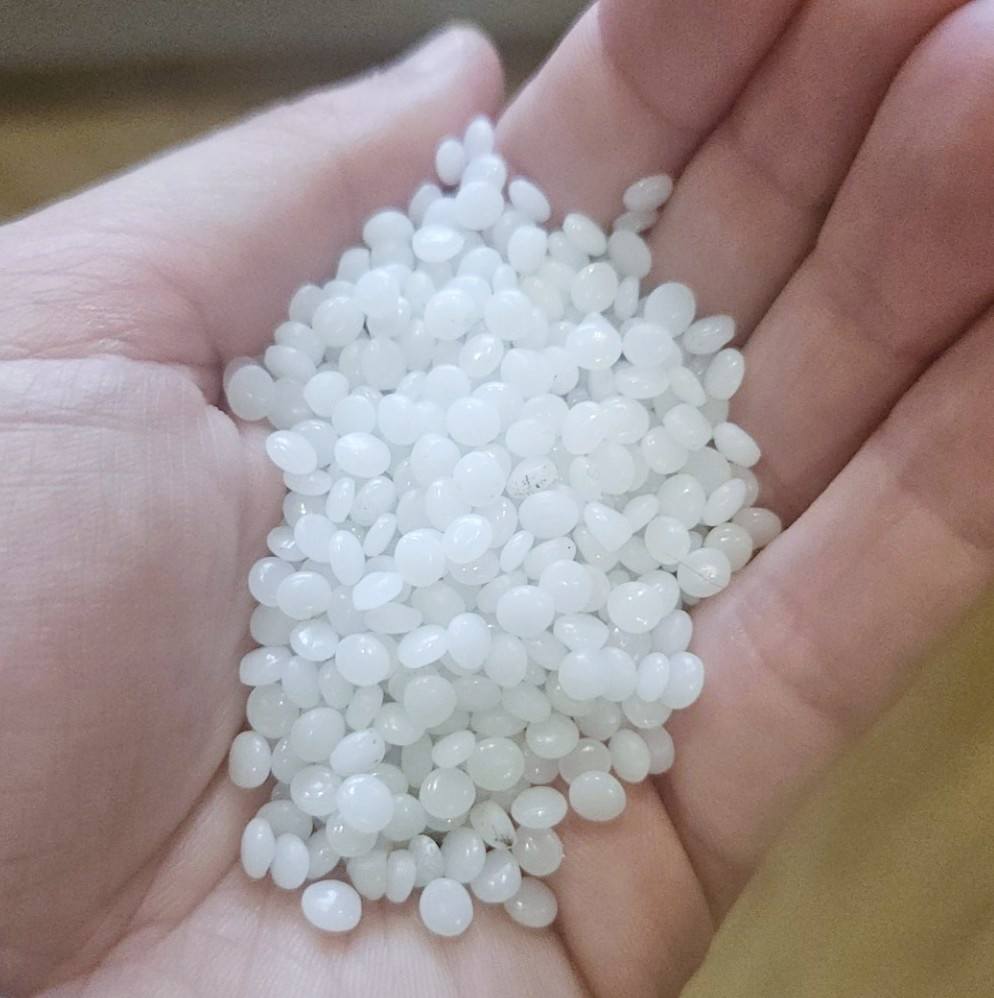 Small plastic pellets, or nurdles in a hand.